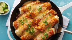 a skillet filled with chicken enchiladas on top of a blue table