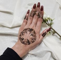 a woman's hand with hennap on it and flowers in the background