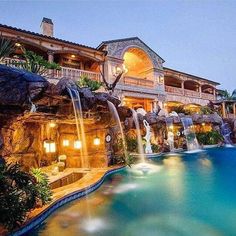 a large house with a pool and waterfall