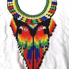 a multicolored necklace is displayed on a white surface