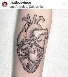 a black and white heart tattoo on the right arm with waves coming out of it