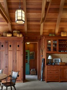 a dining room with wood paneling and wooden furniture in the center, along with an open bookcase