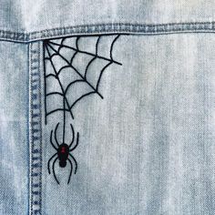 a spider webs through the back pocket of a jean jacket