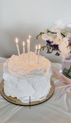 a cake with white frosting and lit candles