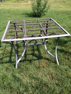 an old metal table sitting in the grass