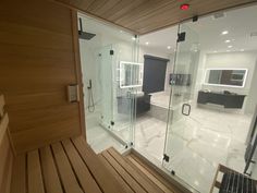 a bathroom with a wooden bench and glass walls