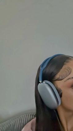 a woman with headphones on her ears is sitting in a chair and looking up