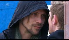 a man in a hooded jacket looking at another man