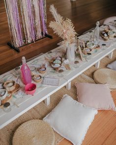 the table is set up with pink and white decorations on it, along with other items