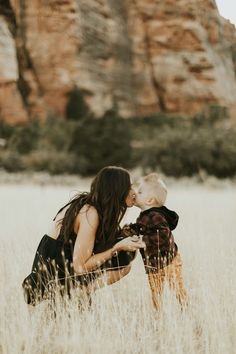 a mother kissing her son in the middle of a field