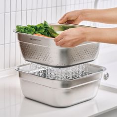 two stainless steel colanders stacked on top of each other with vegetables in them