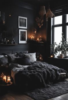 a dark bedroom with candles and pictures on the wall above the bed, along with an area rug