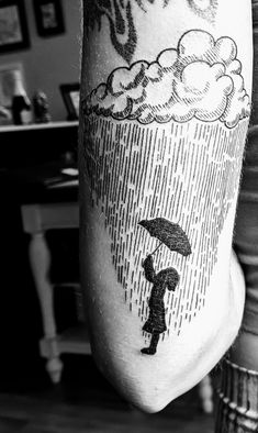 a person holding an umbrella in the rain with clouds above them on their leg,