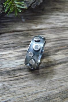 This unisex statement ring is made with 1/4 inch sterling silver in a thick gauge making the piece very sturdy. The band is adorned with sterling elements that vary in size The entire piece was oxidized and polished offering an industrial appearance. This piece is perfect for a man or a woman. Upon purchase send me a message with the ring size. Made to order. To make my pieces withstand loving wear and the test of time, each bracelet is made with very thick gauges of sterling silver. Great thoug Unique Stamped Ring Jewelry, Unique Everyday Sterling Silver Rings, Unique Sterling Silver Round Band Ring, Unique Stamped Silver Rings, Hand Forged Sterling Silver Round Ring, Modern Sterling Silver Rings With Oxidized Finish, Sterling Silver Rings With Oxidized Finish, Brutalist Sterling Silver Rings With Oxidized Finish, Adjustable Brutalist Jewelry Gift