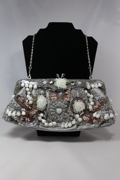 For your consideration is a Vintage Lexy International Inc. clutch style beaded handbag that dates to the mid 1900's. This clutch is in excellent condition (tag still attached) and is loaded with gorgeous rhinestones, beads, sequence and many other textiles and textures. The interior is lined with silver silk, the closure is a silver tone and rhinestone clasp and the clutch also comes with an attached silver toned chain for the option of wearing as a purse. This bag is perfect for a wedding, pro Elegant Rectangular Clutch For Vintage Events, Elegant Beaded Evening Bag For Vintage Events, Elegant Silver Evening Bag For Vintage Events, Vintage Embellished Clutch Shoulder Bag, Vintage Party Clutch With Pearl Handle, Vintage Clutch Evening Bag For Events, Vintage Embellished Shoulder Bag For Wedding, Handmade Victorian Evening Bag, Vintage Embellished Wedding Shoulder Bag