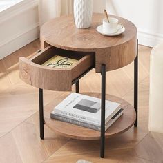 a wooden table with two drawers and a coffee cup on top, in front of a window