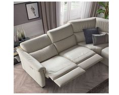 a white leather sectional sofa with pillows on it