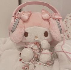 a stuffed animal with headphones on sitting on a bed