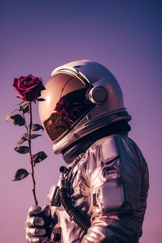 a man in an astronaut suit holding a rose up to his face and looking at the sky