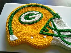 a green bay packers helmet cake on a white plate