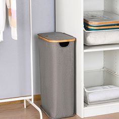 a white shelf with two bins and some towels