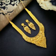 This exquisite gold-plated haram necklace set is a true testament to Indian craftsmanship. The intricate design, featuring delicate floral motifs and intricate detailing, exudes timeless elegance. The long, cascading necklace is complemented by matching earrings, creating a harmonious and luxurious ensemble. The rich gold plating adds a touch of opulence, making this set perfect for special occasions and festive celebrations. Set of include-: 1 Necklace 2 Piece Earrings 1 Necklace Back Dori/chai Luxury Gold Sets With Zari Weaving, Festive Gold Sets For Navratri, Gold Sets With Pallu For Navratri, Elegant Gold Sets For Navratri, Gold Sets With Pallu For Festivals, Gold Sets With Pallu Detail For Festivals, Traditional Gold Sets For Festive Occasions, Gold Bollywood Sets For Diwali, Bollywood Style Gold Sets For Diwali