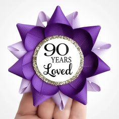 a purple bow with the words 90 years loved on it