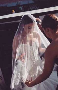 the bride is getting ready to walk down the aisle in her wedding dress and veil