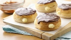 four cookies with chocolate icing on a cutting board