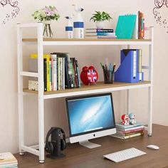 there is a computer on the desk with books and other items in front of it