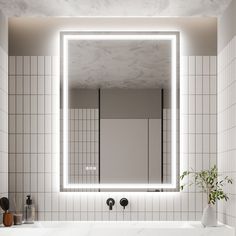 a bathroom sink with a large mirror above it and a potted plant in the corner