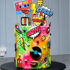 a multicolored cake with various stickers on it