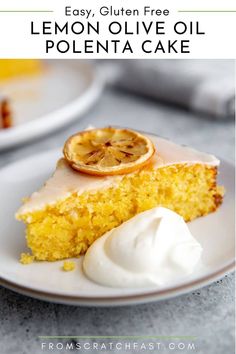 a slice of lemon olive oil polenta cake on a white plate with whipped cream