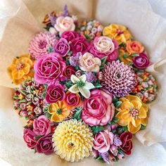 a bouquet of colorful flowers sitting on top of paper