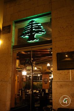 the entrance to a restaurant lit up with green lights