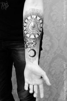 a person with a tattoo on their arm and the hand is pointing towards an object