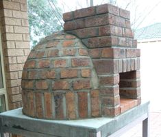 a brick oven sitting on top of a cement block