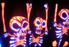 three skeletons with neon lights on their faces