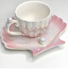 a cup and saucer sitting on top of a pink plate