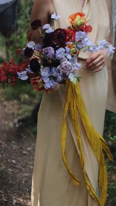 a woman in a dress holding a bouquet of flowers