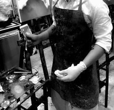 a woman wearing an apron and gloves in a kitchen