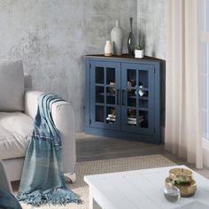 a living room with a white couch and blue cabinet