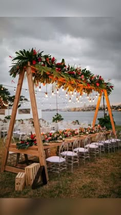 a wooden table topped with flowers and greenery