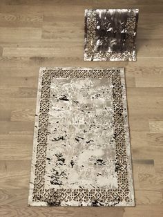 a white rug sitting on top of a wooden floor next to a piece of metal foil