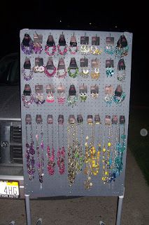 there is a large display with many pairs of earrings on the wall next to a car