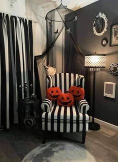 a striped chair with pumpkins on it in front of a black and white curtain