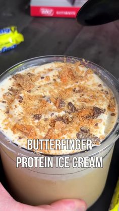 a hand holding a container of butterfingerer protein ice cream with the text butterfingerer protein ice cream