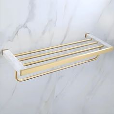 a gold towel rack on a marble wall