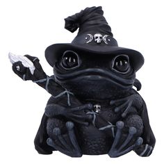 a statue of a frog wearing a witches hat and holding a skull in its hand