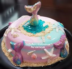 there is a cake that has been decorated with mermaid decorations on the top and bottom